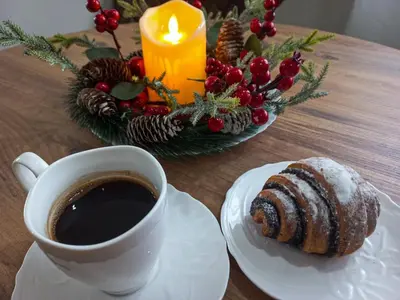 a table with a cup of coffee and a pastry at Apartman Marić Raj in Vrnjačka Banja