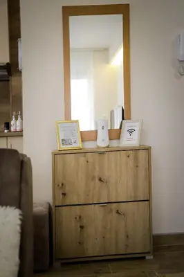 a mirror on top of a dresser in a room at Apartman Marić Raj in Vrnjačka Banja