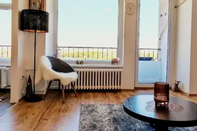 a living room with a table and a large window at Tizza apartment - Modern flat above the city center in Niš