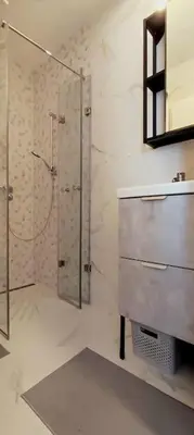a bathroom with a shower and a sink and a mirror at Tizza apartment - Modern flat above the city center in Niš