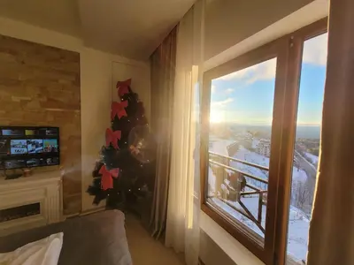a room with a christmas tree next to a window at Milmari N66 in Kopaonik