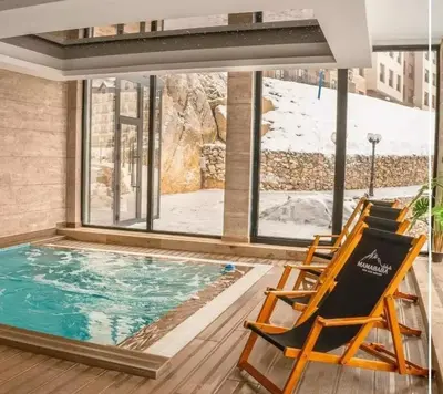 a room with a pool and two chairs and a window at Milmari N66 in Kopaonik