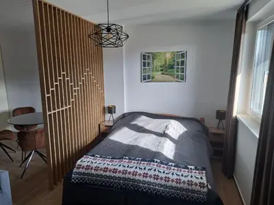 a bedroom with a bed with a wooden headboard at Twin mountain in Kopaonik