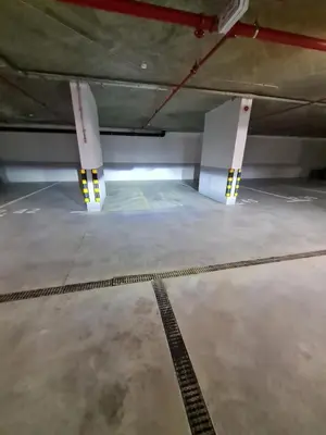 a parking lot with two white columns in a parking garage at Kopaonik Woodside in Kopaonik