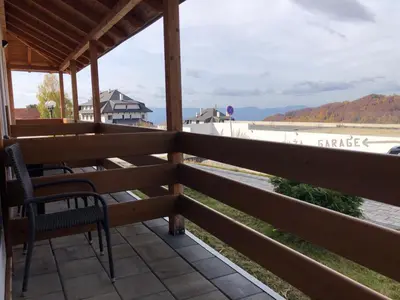 a porch with chairs and a view of the water at Apartman K3 Milmari Kopaonik in Kopaonik