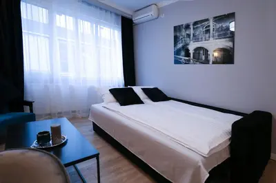 a bedroom with a bed and a table in a room at Heart of Niš in Niš