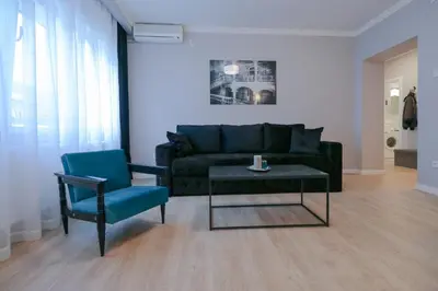 a living room with a couch and a table and a chair at Heart of Niš in Niš