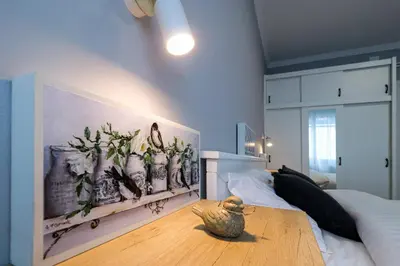 a bedroom with a bed and a vase on a wooden table at Heart of Niš in Niš