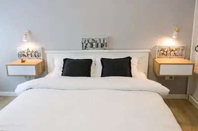 a bedroom with a white bed with two night stands at Heart of Niš in Niš