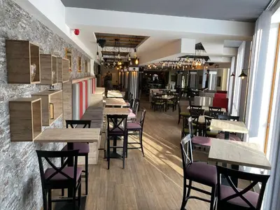 a restaurant with wooden tables and purple chairs at PLEASURE LUX GOLD in Kopaonik