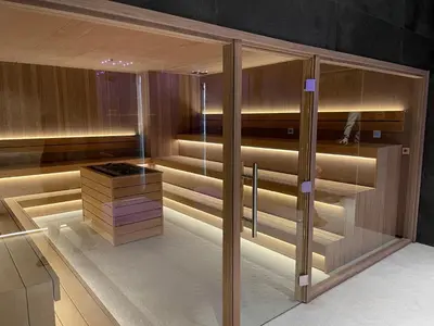 a sauna with wooden panels and glass doors at Woodside Apartment 431, Kopaonik - One separate bedroom 35m2- FREE Parking & SPA in Kopaonik
