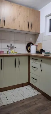 a kitchen with white cabinets and a white rug at Sova Kopaonik in Kopaonik