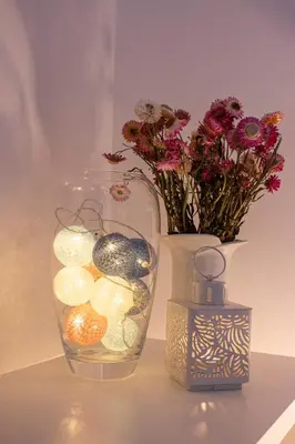 a vase with flowers and a candle and a vase with flowers at Town Space Apartment Niš in Niš