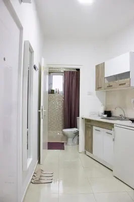 a white bathroom with a toilet and a sink at Town Space Apartment Niš in Niš