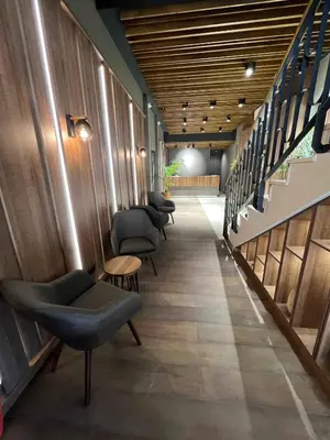 a corridor with chairs and stairs in a building at Kopaonik Apart Bela Reka Brzece in Brzeće