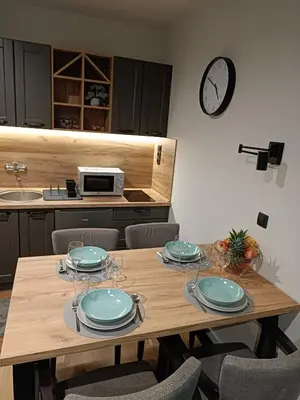 a wooden table with plates and wine glasses on it at Kopaonik Apart Bela Reka Brzece in Brzeće