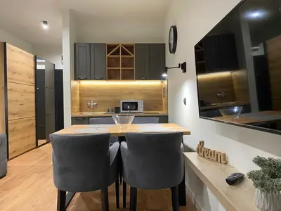 a kitchen with a wooden table and two chairs at Kopaonik Apart Bela Reka Brzece in Brzeće