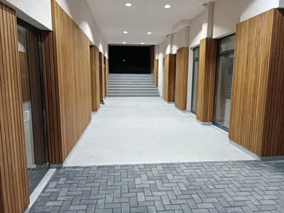 an empty hallway in a building with wooden doors and stairs at Kopaonik Apart Bela Reka Brzece in Brzeće