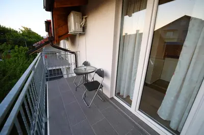 a balcony with a table and chairs on the side of a house at Bumerang in Soko Banja