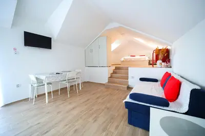 a living room with a couch and a table and a staircase at Bumerang in Soko Banja