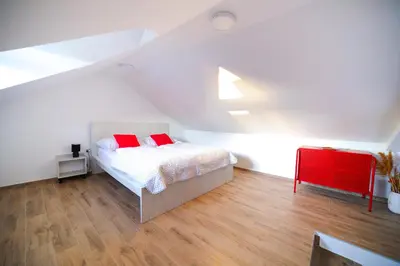 a bedroom with a bed with two red pillows at Bumerang in Soko Banja