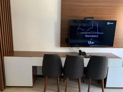a dining table with chairs and a tv on a wall at Kopaonik Zoned 2 in Kopaonik