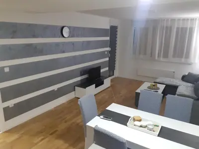 a living room with a couch and a table and chairs at Vlyche apartment FREE PARKING in Niš