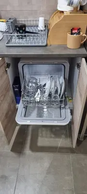 an open dishwasher in a kitchen under a counter at Vlyche apartment FREE PARKING in Niš