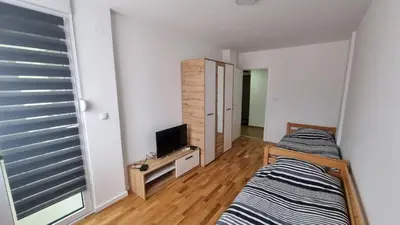 a bedroom with two beds and a television in it at Vlyche apartment FREE PARKING in Niš
