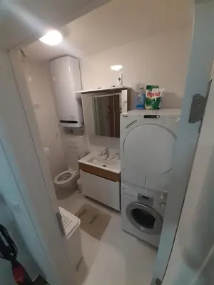 a bathroom with a washing machine and a sink at Vlyche apartment FREE PARKING in Niš