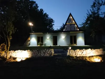 a house with a pointed roof at night at Brvnara Riva in Niš