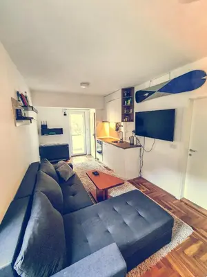a living room with a blue couch and a kitchen at The spots - 300m from the Gondola in Brzeće