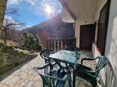 a table and two chairs on a balcony with a view at APARTMAN NA STAZI - Bela Reka, Kopaonik in Brzeće
