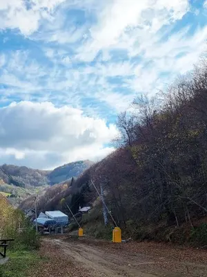 a dirt road leading to a house on a hill at APARTMAN NA STAZI - Bela Reka, Kopaonik in Brzeće