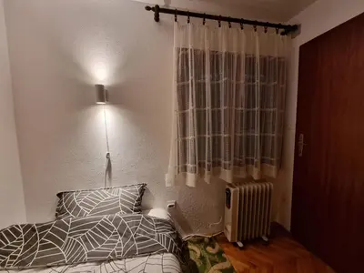 a bedroom with a bed and a lamp and a window at APARTMAN NA STAZI - Bela Reka, Kopaonik in Brzeće
