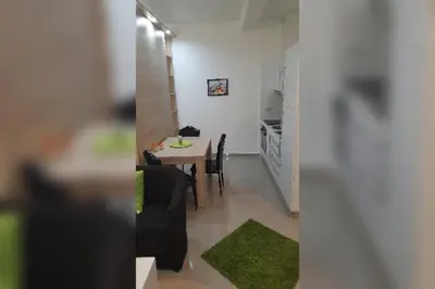 a dining room and kitchen with a table and chairs at LUX Apartmani Jagodina in Jagodina