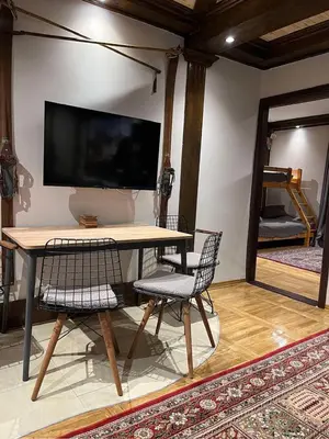 a table with two chairs and a large television on a wall at Winter magic centar in Kopaonik