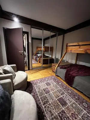 a room with two beds and a couch and a rug at Winter magic centar in Kopaonik