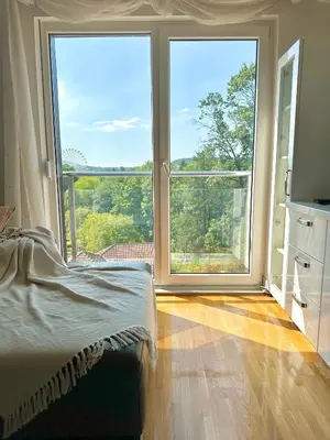 a bedroom with large windows and a bed and a television at Prelep Pogled, Elegantan Komfor Blizu Centra, Besplatan Parking, Apartman Floresta in Vrnjačka Banja