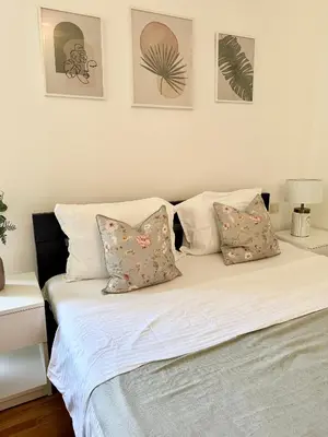 a bed with four pillows on it in a bedroom at Prelep Pogled, Elegantan Komfor Blizu Centra, Besplatan Parking, Apartman Floresta in Vrnjačka Banja