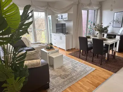 a living room with a table and a dining room at Prelep Pogled, Elegantan Komfor Blizu Centra, Besplatan Parking, Apartman Floresta in Vrnjačka Banja
