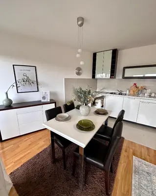 a white dining room table with black chairs in a kitchen at Prelep Pogled, Elegantan Komfor Blizu Centra, Besplatan Parking, Apartman Floresta in Vrnjačka Banja