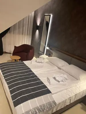 a bedroom with a large bed and a chair at Woodside Duplex Apartment Ski in Ski out with garage in Kopaonik