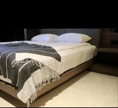 a bed with a black and white blanket and pillows at Woodside Duplex Apartment Ski in Ski out with garage in Kopaonik