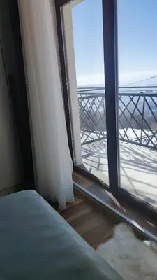 a bedroom with a window with a view of the ocean at President Kop apartmani Vista & Sol in Kopaonik