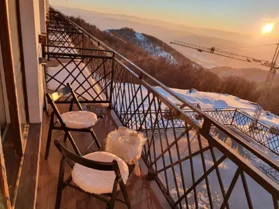 two chairs and a table on a balcony with a view at President Kop apartmani Vista & Sol in Kopaonik