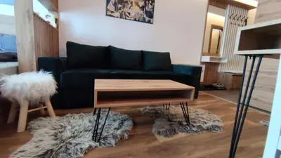 a living room with a couch and a coffee table at President Kop apartmani Vista & Sol in Kopaonik