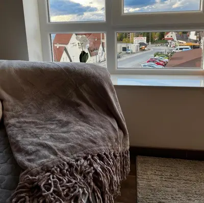 a blanket sitting on a couch in front of a window at Apartments Myna in Kraljevi Cardaci in Kopaonik