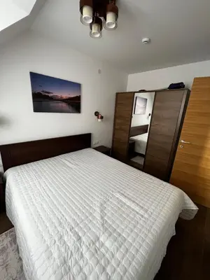 a bedroom with a white bed and a mirror at Apartments Myna in Kraljevi Cardaci in Kopaonik