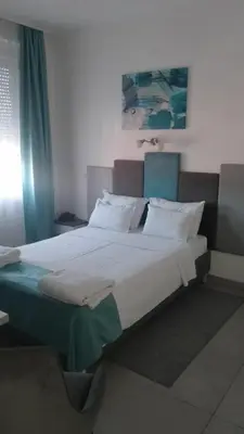 a bedroom with a large bed with white sheets and pillows at AS APARTMANI PIROT in Pirot